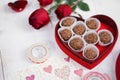 Valentine`s day. Nutty chocolate in a red heart box and red roses for Valentine`s or anniversary present. Soft focus on the nutt
